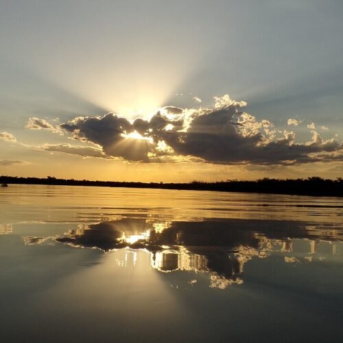 Pôr do sol no lago com céu alaranjado