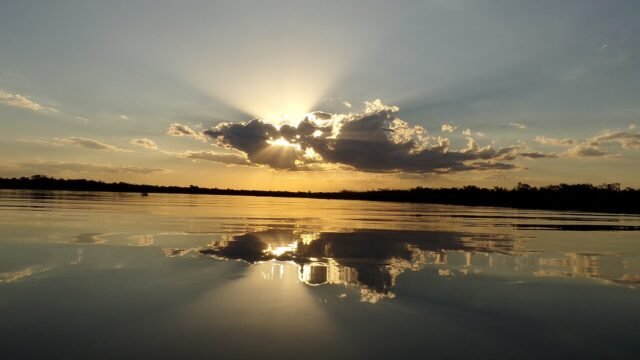 Pôr do sol no lago com céu alaranjado