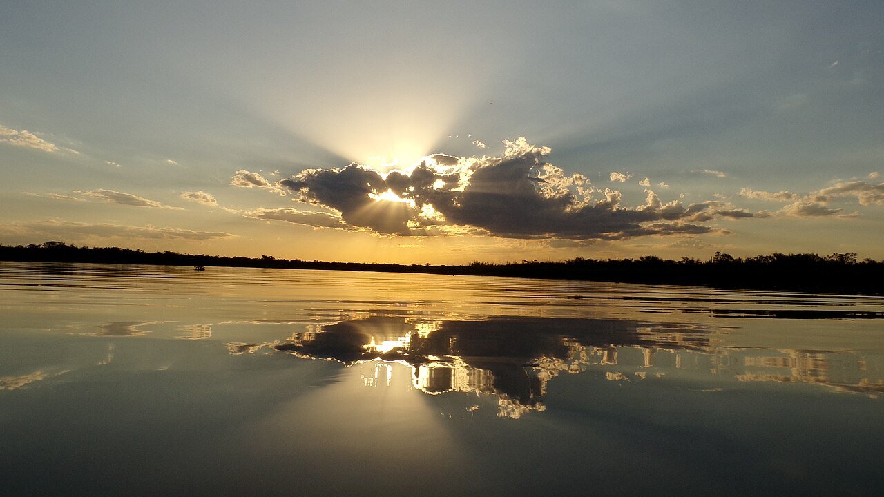 Pôr do sol no lago com céu alaranjado