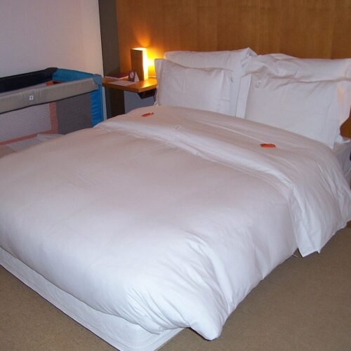 Quarto de pousada com cama de casal arrumada