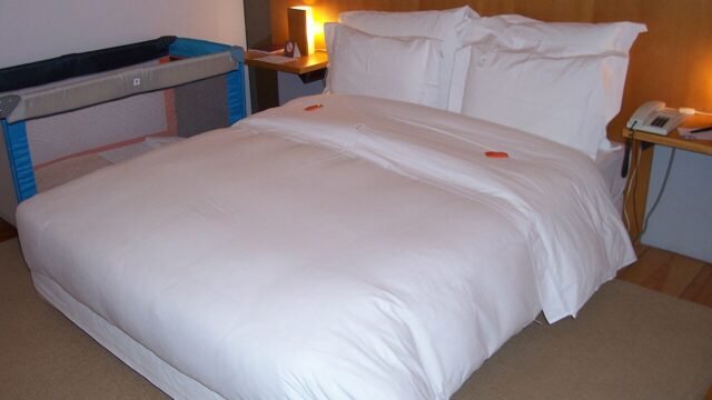 Quarto de pousada com cama de casal arrumada